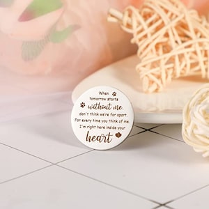 May include: White round memorial token with a paw print and the text "When tomorrow starts without me. don't think we're far apart. For every time you think of me. I'm right here inside your heart"