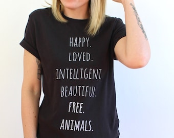 May include: A black t-shirt with white text that reads "HAPPY. LOVED. INTELLIGENT. BEAUTIFUL. FREE. ANIMALS."