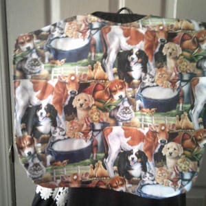 May include: A patterned tote bag featuring a collage of farm animals, including cows, dogs, and cats. The design incorporates various breeds and poses, with a black handle at the top. The bag has a black trim and a white lace detail.
