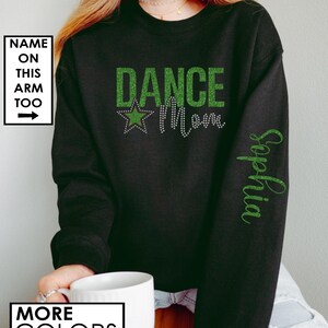 May include: Black sweatshirt with green glitter text that reads "Dance Mom" with a green star. The text "Sophia" is written in green glitter on the right sleeve.