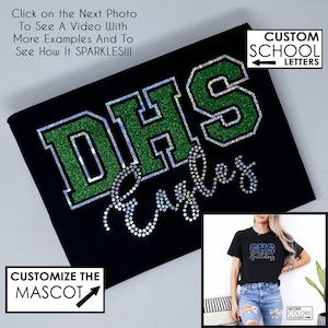 May include: Black t-shirt with the letters "DHS" in green glitter and the word "Eagles" in silver rhinestones. The image also includes a smaller image of a t-shirt with the text "GHS Bulldogs". Text on the image says "Customize the Mascot" and "Custom School Letters".