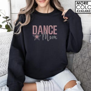 May include: Black sweatshirt with a pink glitter design that says "Dance Mom" with a pink glitter star.