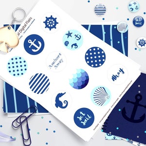 Pu&ograve; includere: Un foglio di adesivi stampabili a tema nautico con disegni blu e bianchi. Gli adesivi raffigurano ancore, conchiglie, una stella marina, un cavalluccio marino, un timone e le parole "Anchors Away", "Ahoy" e "Set Sail".