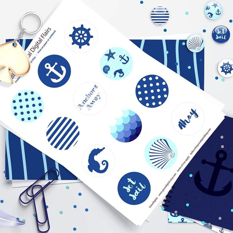 Pu&ograve; includere: Un foglio di adesivi stampabili a tema nautico con disegni blu e bianchi. Gli adesivi raffigurano ancore, conchiglie, una stella marina, un cavalluccio marino, un timone e le parole "Anchors Away", "Ahoy" e "Set Sail".