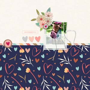 May include: A scrapbook page with a photo of two girls hugging in a park. The photo is surrounded by a floral design and hearts. The text "LOVE THIS MEMORY OF US" is printed on a white rectangle at the top of the page.