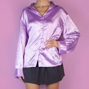 The Y2K Lilac Satin Blouse is a vintage bright pinkish-purple shirt with a collar and buttons. Elegant preppy 2000s office work blouse.