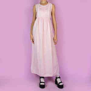 The Vintage 90s Pink Slip Maxi Dress is a light pastel pink polka dot midi dress featuring white lace details and ties at the back. Romantic 1990s night dress.