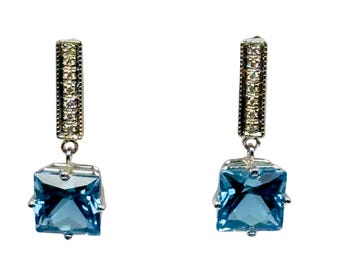 3.12 carats Blue Topaz dangle earrings in 14 k white gold.  Accented with .14 carats of diamonds.
