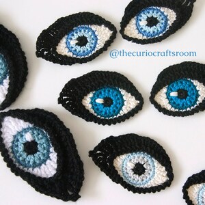 May include: A set of seven crocheted eyes in various sizes. The eyes are made with black, white, blue, and light blue yarn. The eyes are all oval shaped and have a black pupil in the center. The eyes are perfect for adding a whimsical touch to any craft project.