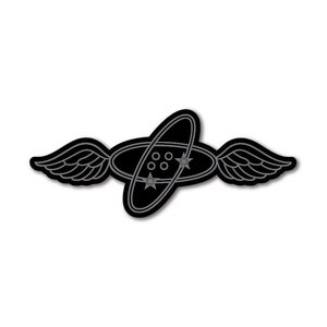 May include: Black and gray stylized illustration of a winged atom with five dots in the center. The atom is surrounded by a circle with two stars.