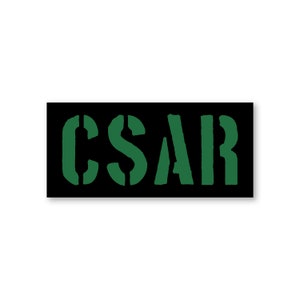 May include: A black rectangular patch with the word "CSAR" in green letters.