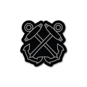 Puede incluir: Pegatina negra y gris con un diseño de ancla cruzada. Los anclajes tienen un detalle de cuerda y están rodeados por un círculo.