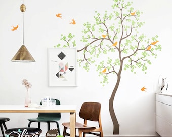 May include: A wall decal featuring a brown tree trunk with light green leaves and small orange birds perched on the branches. Additional orange birds are flying around the tree. The design includes the text Olivia DESIGN with color labels.
