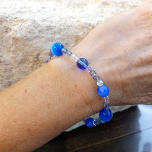 Puede incluir: Un brazalete de cuentas azules y transparentes con una banda el&aacute;stica extensible. El brazalete presenta cuentas redondas azules y cuentas de vidrio transparentes.