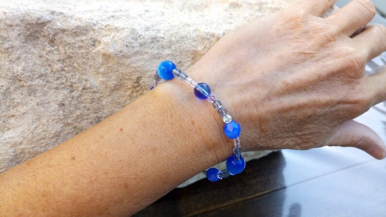 Puede incluir: Un brazalete de cuentas azules y transparentes con una banda el&aacute;stica extensible. El brazalete presenta cuentas redondas azules y cuentas de vidrio transparentes.