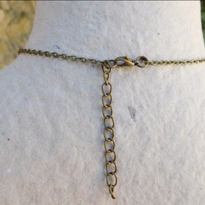 Peut inclure: Un collier en cha&icirc;ne bronze avec une fermeture &agrave; fermoir mousqueton. La cha&icirc;ne est compos&eacute;e de petits cercles li&eacute;s.