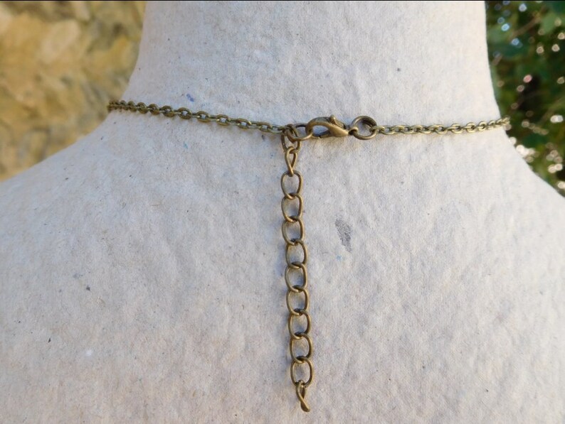 Peut inclure: Un collier en cha&icirc;ne bronze avec une fermeture &agrave; fermoir mousqueton. La cha&icirc;ne est compos&eacute;e de petits cercles li&eacute;s.