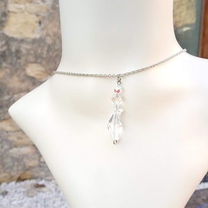 May include: A silver chain necklace with a clear crystal pendant shaped like a leaf.