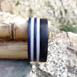 May include: Close-up of a bamboo flute with a black and white striped band around the end.