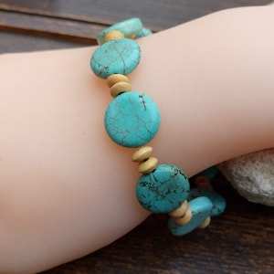 Op de afbeelding: Turquoise en houten kralen armband. De armband heeft ronde turquoise kralen met een gemarmerd patroon en kleinere ronde houten kralen.