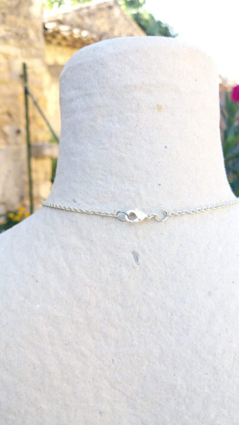 May include: A silver chain necklace with a lobster clasp closure.