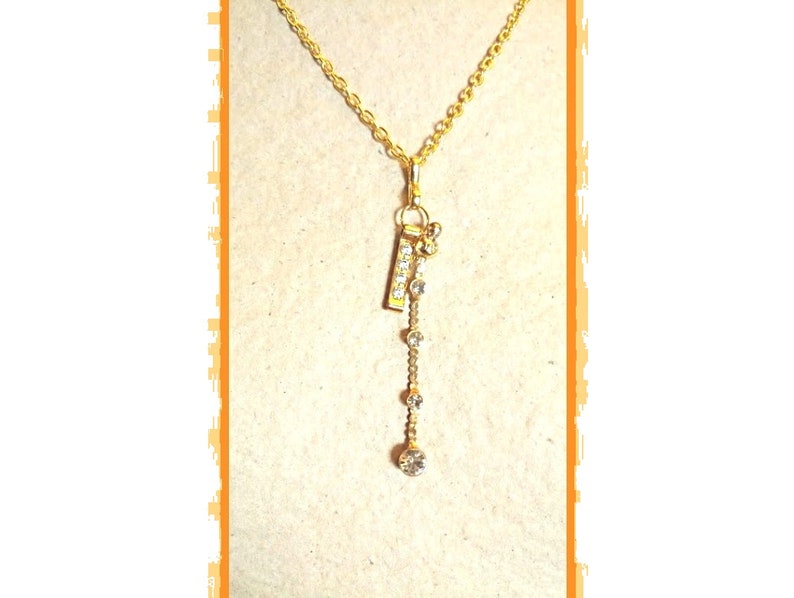 Gold chain rhinestone pendant necklace very glamorous and a gold rhinestone metal charm with a gold rhinestone-plated charm