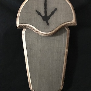 May include: A gray wooden wall mount with a bird footprint design. The mount is designed to hold a bird specimen.