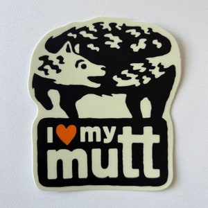 May include: Black and white sticker with a cartoon dog with a heart that says "I love my mutt". The heart is orange.