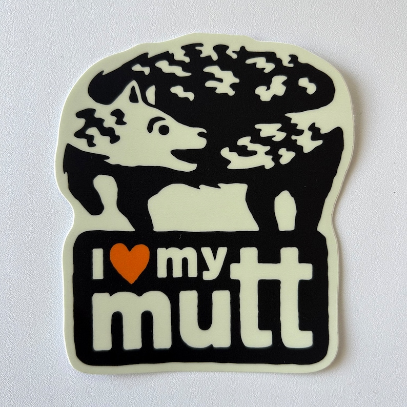 May include: Black and white sticker with a cartoon dog with a heart that says "I love my mutt". The heart is orange.