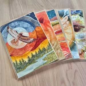 Puede incluir: Conjunto de cinco tarjetas de felicitación de acuarela con escenas de la naturaleza. Las tarjetas están impresas en papel grueso y tienen un acabado texturizado. Las tarjetas están en blanco en el interior para escribir mensajes.