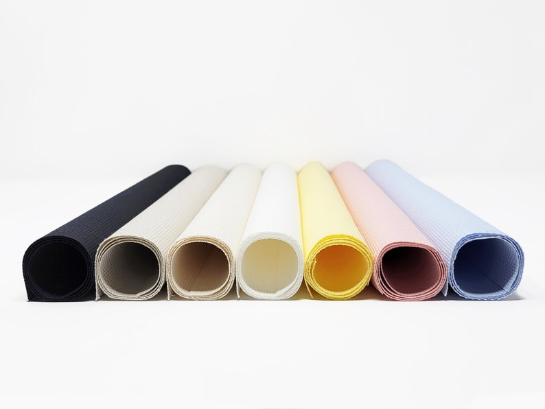 May include: Eight rolls of fabric in various colors, including black, beige, white, yellow, pink, and blue. The fabric is rolled up and the ends are visible.