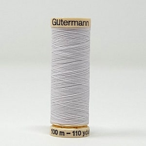 May include: A spool of Gutermann thread in a light grey colour. The spool is labelled "Gutermann" and "100 m - 110 yds".