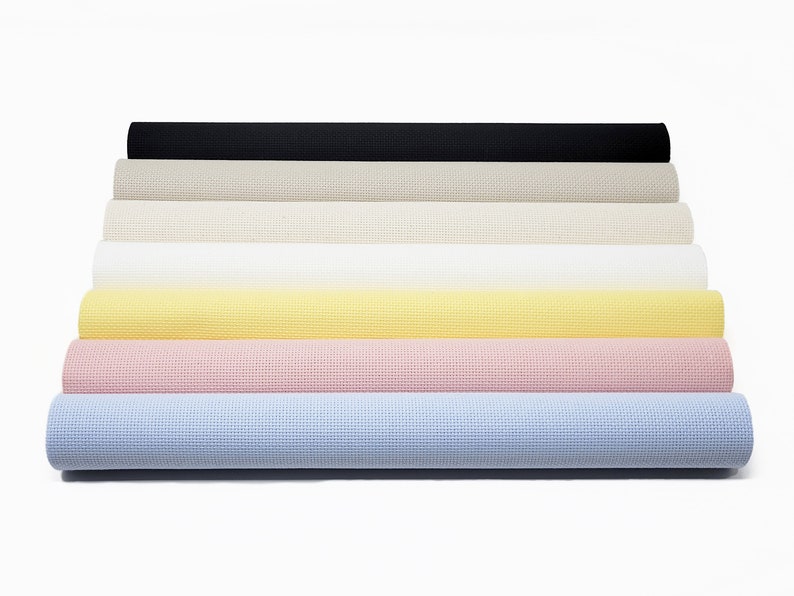 May include: A set of eight rolled-up fabric swatches in various colors, including black, beige, white, yellow, pink, and light blue. The fabric has a textured, woven appearance.