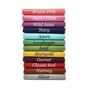 May include: A selection of fabric swatches in a range of colours, such as bright pink, navy, and classic red. Each fabric is labelled with its colour name in white text. The swatches are stacked against a white backdrop.