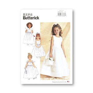 Könnte beinhalten: Ein Schnittmuster für drei verschiedene Stile von weißen Blumenmädchenkleidern. Das Schnittmuster ist von Butterick und trägt die Nummer B3351.