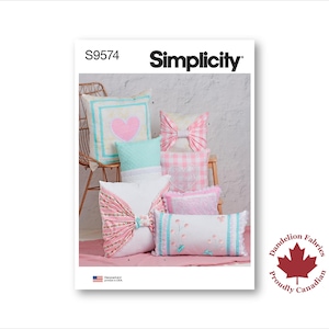 May include: Simplicity pattern S9574 showcasing decorative pillows with heart, bow, and floral designs. The pillows use pastel pinks, blues, and whites. The image includes the Dandelion Fabrics logo and a "Proudly Canadian" stamp.