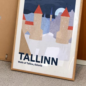 May include: Framed art print showing a stylized illustration of Tallinn, Estonia. The artwork depicts the city's walls and towers with red roofs, set against a night sky with a full moon. The word "TALLINN" is prominently displayed.