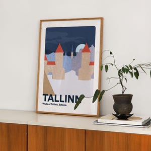 May include: A framed art print showing a stylized illustration of Tallinn, Estonia. The artwork features two towers with red roofs under a dark blue sky. The print is labelled "TALLINN Walls of Tallinn, Estonia."
