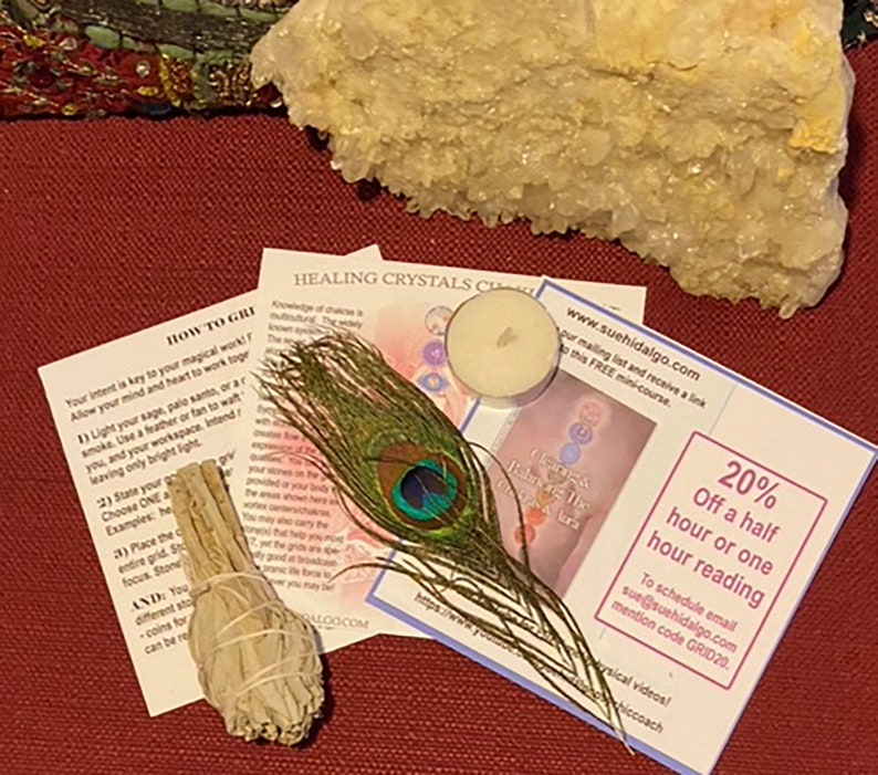 Puede incluir: Un palo de limpieza de salvia blanca, una vela de t&eacute; blanca, una pluma de pavo real y un c&uacute;mulo de cristales blancos sobre una superficie roja. La imagen tambi&eacute;n incluye dos tarjetas con texto que dice "How to Grid" y "Healing Crystals Chakra". La segunda tarjeta tambi&eacute;n incluye una direcci&oacute;n de sitio web y una oferta de descuento: "20% Off a half hour or one hour reading".