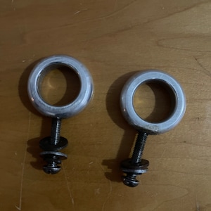 May include: Two silver metal rings with a screw and washer attached to each. The rings are about 2 inches in diameter.