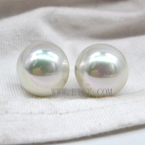 May include: Two large, white, round pearls with an iridescent sheen.