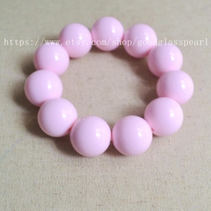 May include: A light pink bracelet composed of large, round beads. The beads are evenly spaced and strung together to form a circular shape. The text "https://www.etsy.com/shop/goodglasspearl" is visible in the image.