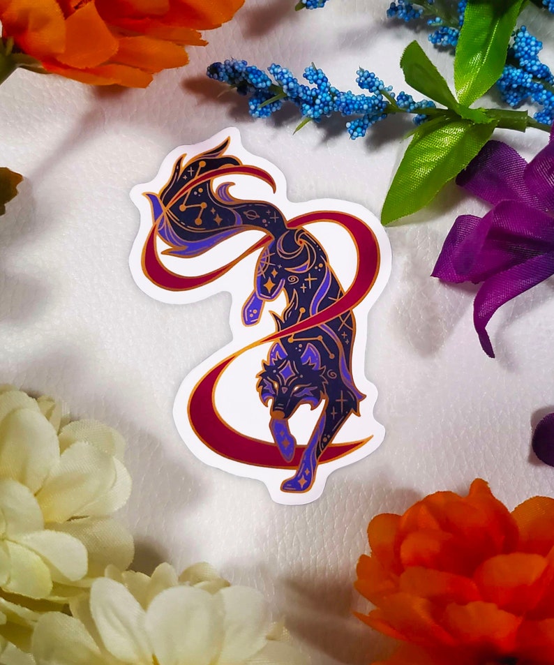 May include: A sticker featuring a stylized black wolf with purple and gold details. The wolf is surrounded by a red and gold crescent moon shape. The wolf's fur is patterned with stars and other celestial symbols.