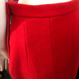 K&ouml;nnte beinhalten: Ein roter Wollrock mit einem Rei&szlig;verschluss an der Seite und einer Naht in der Mitte des R&uuml;ckens.