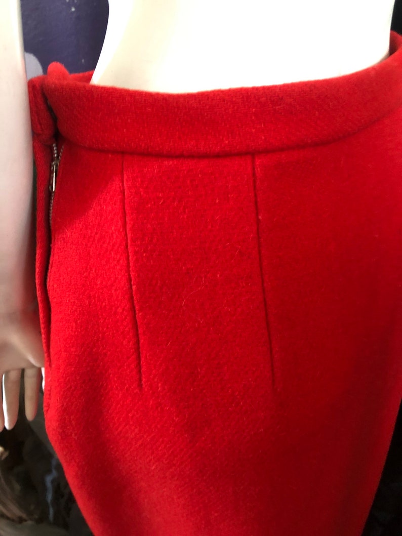 K&ouml;nnte beinhalten: Ein roter Wollrock mit einem Rei&szlig;verschluss an der Seite und einer Naht in der Mitte des R&uuml;ckens.