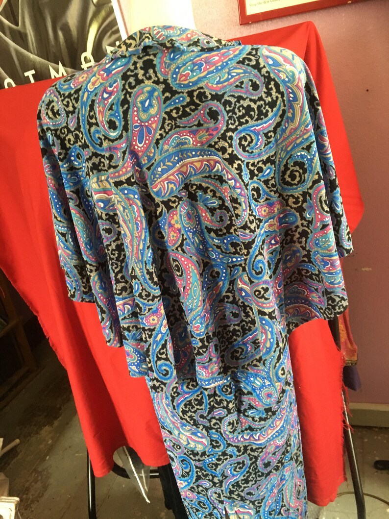 May include: A black and blue paisley patterned dress with a long skirt and short sleeves.