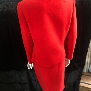 K&ouml;nnte beinhalten: Ein roter Wollrock-Anzug mit einem figurbetonten Rock und einer Jacke mit Stehkragen.