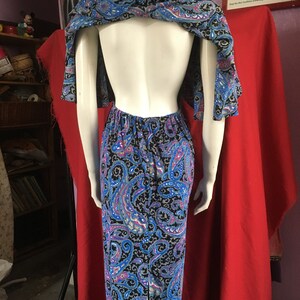 May include: A blue and black paisley print maxi dress with a low back and a matching shawl. The dress has a fitted bodice and a flowing skirt.