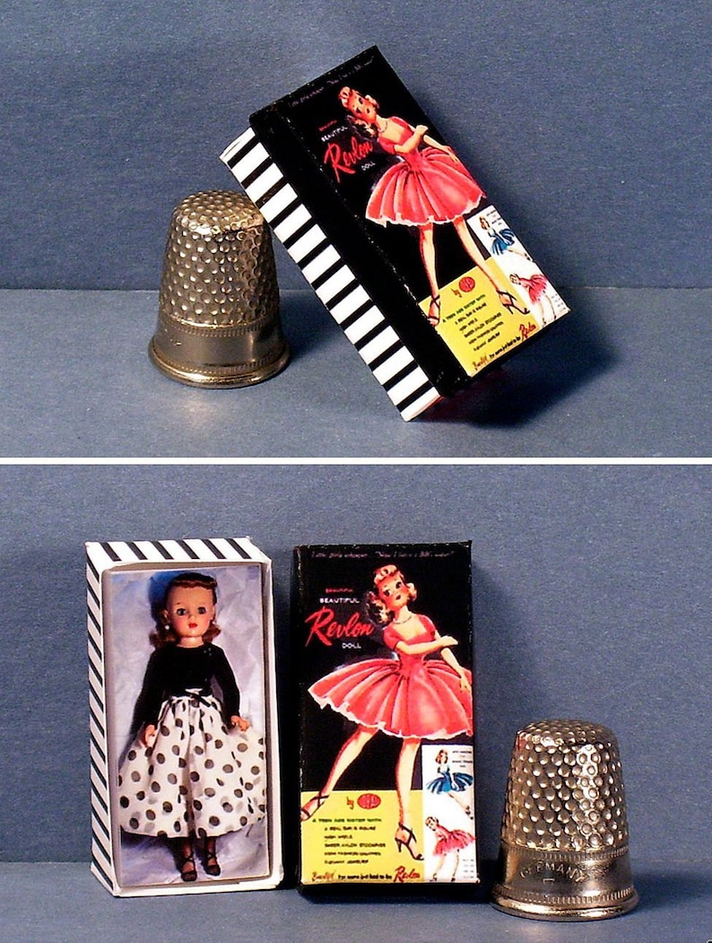 May include: Two boxes of Revlon dolls, one with a doll wearing a black and white polka dot dress and the other with a doll wearing a pink dress. Both boxes have black and white stripes and the text "Beautiful Revlon Doll" on the front.