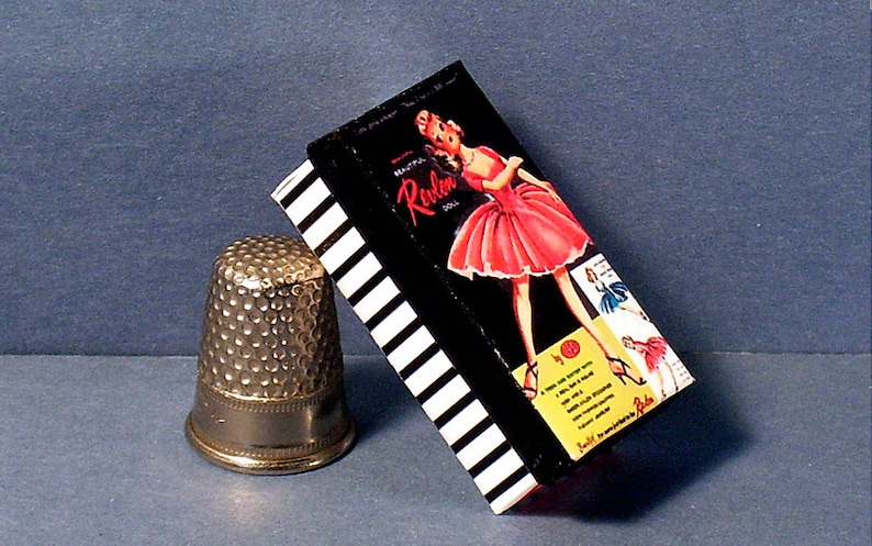 May include: A vintage box of Revlon hosiery with a black and white striped design. The box features a woman in a pink dress and the text "Beautiful Revlon Hosiery".
